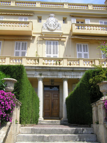 The wooden front door with two stone pillars ateither side and the stone coat of arms above