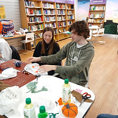 Young people crafting at a table with supplies