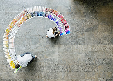 this image shows a man and woman spreading colour cards across the floor