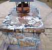 Severely deteriorated chimney crown with exposed aggregate and water damage