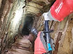 Technician breaking out clay flue tiles to make room for a properly sized stainless-steel liner with insulation mix