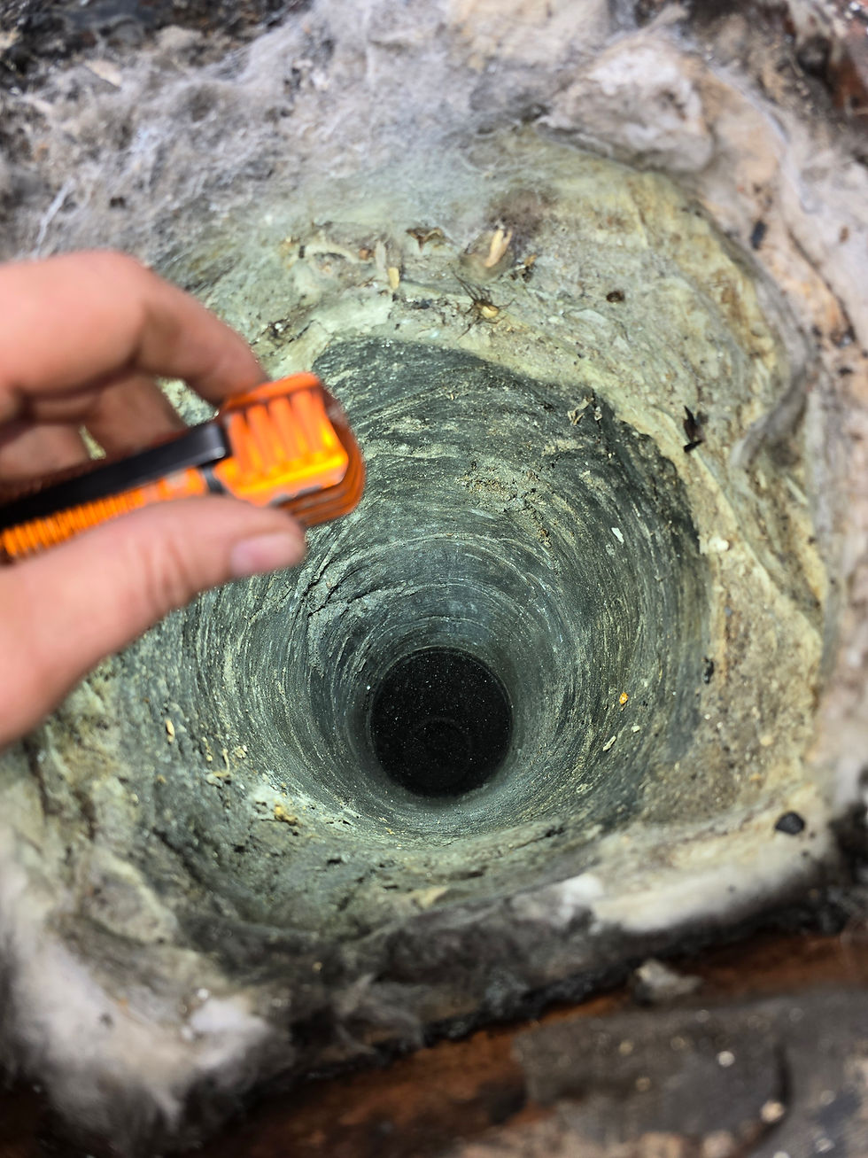 Chimney flue after liner removal showing melted fiberglass insulation bonded to the masonry walls.