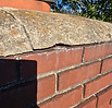 Damaged concrete chimney crown with cracks allowing water intrusion