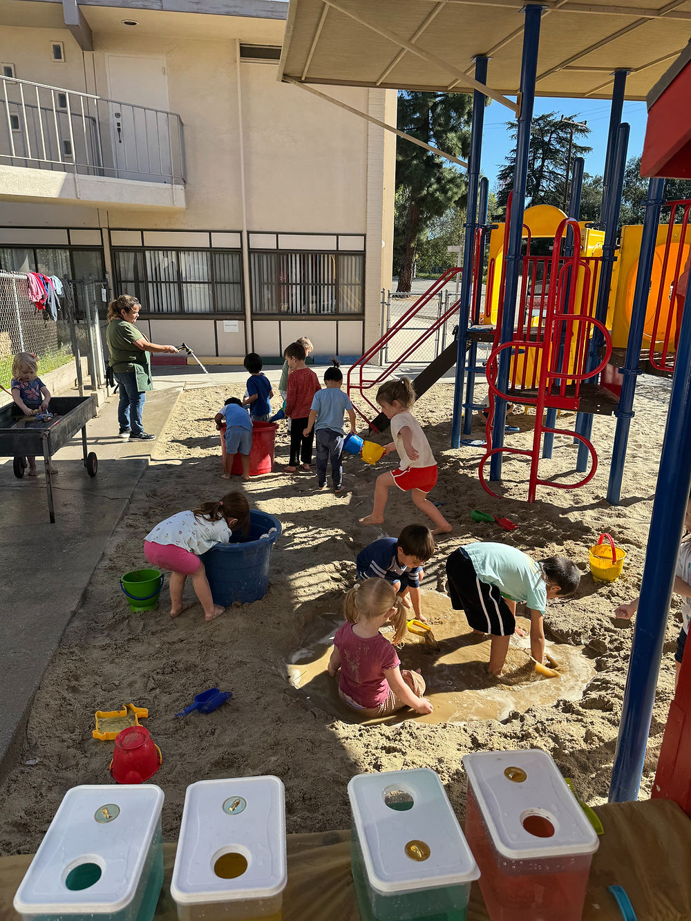 Kids playing in the sand and water at the school playground.