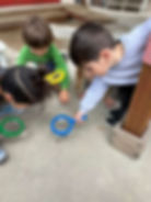 Children using magnifying glasses to explore the ground