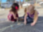 Two children drawing with chalk