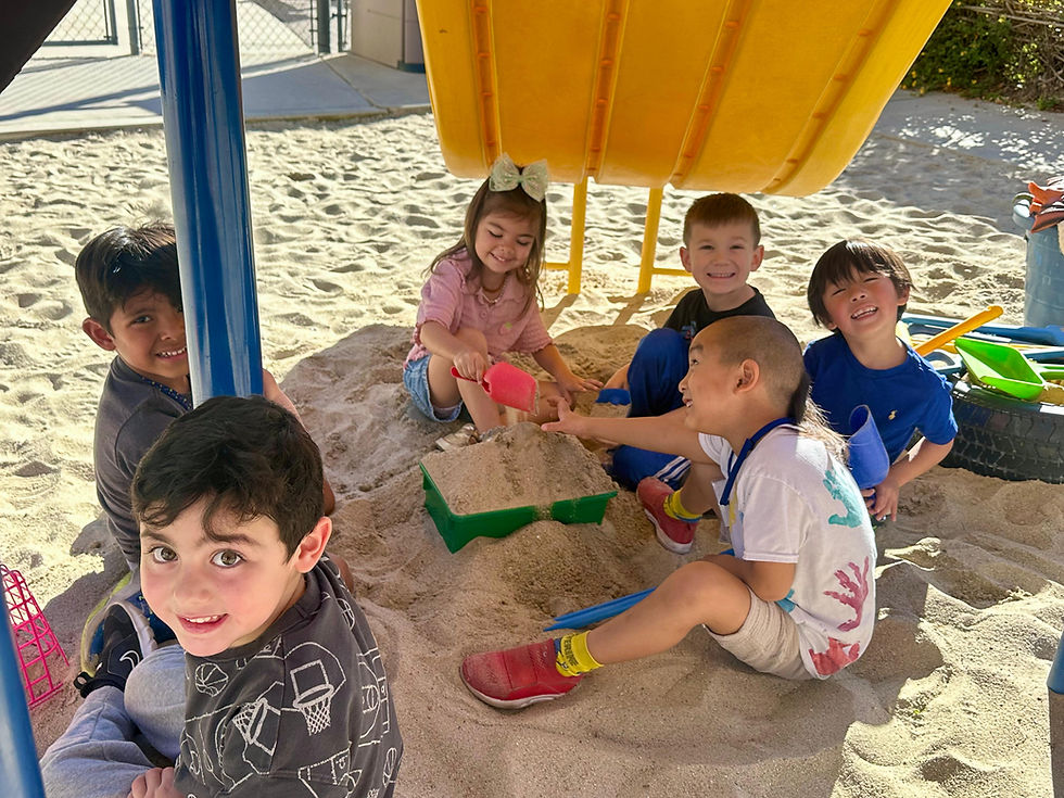 Children 2-5 playing in sandbox at play based preschool