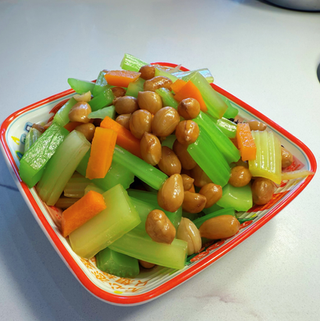 Celery, carrots, and peanuts in a colorful bowl, a healthy dish.