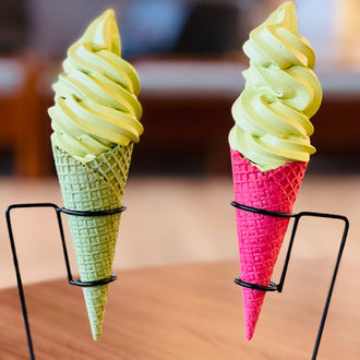 Two matcha ice cream cones, one green and one pink. Momo Matcha.