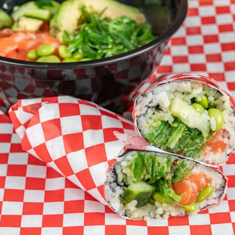 Salmon sushi burrito with seaweed salad and edamame