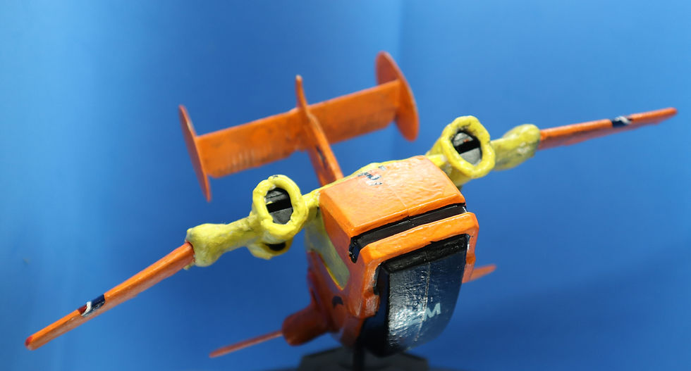Model of a yellow and orange vehicle that looks similar to a small plane with a large passenger section.