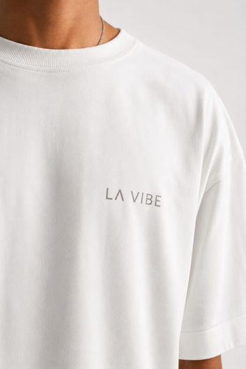 White oversized tee with 'LA VIBE' text