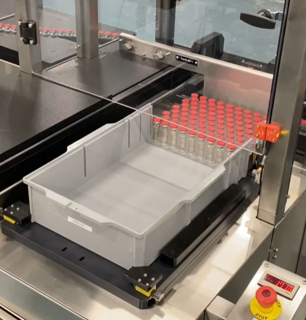 High angle view of automated pharmaceutical production line with vial trays in use