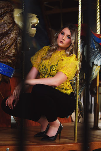Young woman posing in front of a carousel 