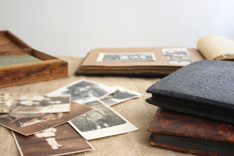 Vintage family photographs and memory albums used to reflect on a loved one's life while writing a meaningful obituary.