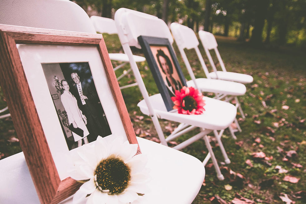 Memorial service chairs displaying framed photographs of loved ones during an outdoor funeral gathering