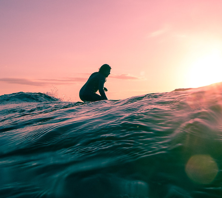 Brand identity design for San Francisco Peninsula, featuring a surfer floating on ocean during sunset
