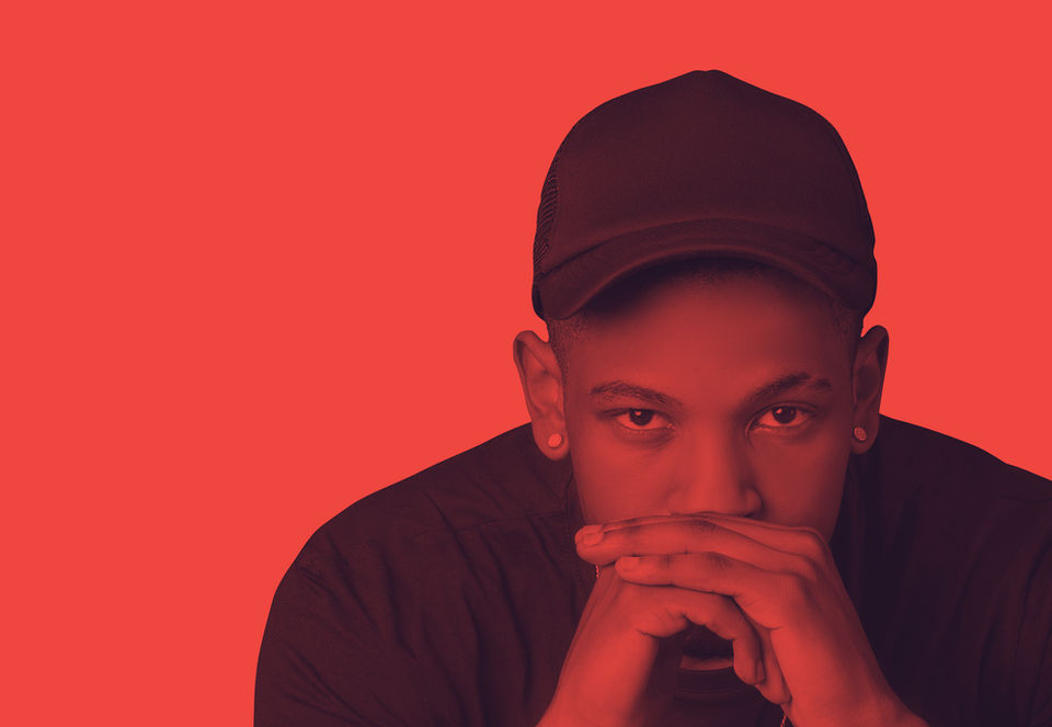 Young man with cap looking at camera against red background, okanii.