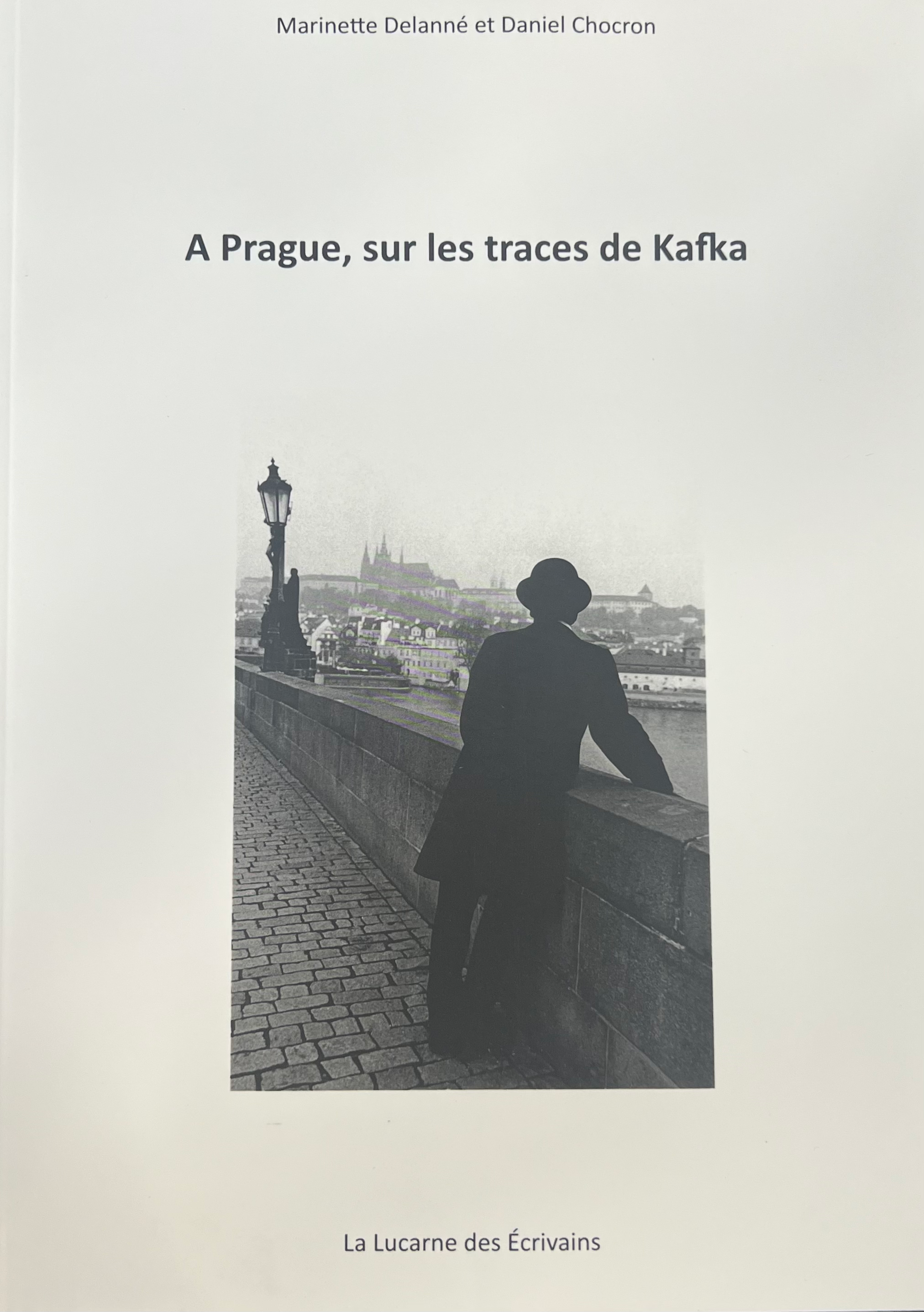 Photo en noir et blanc d'un homme de dos accoudé à la rambarde d'un pont couverture de A Prague sur les traces de Kafka