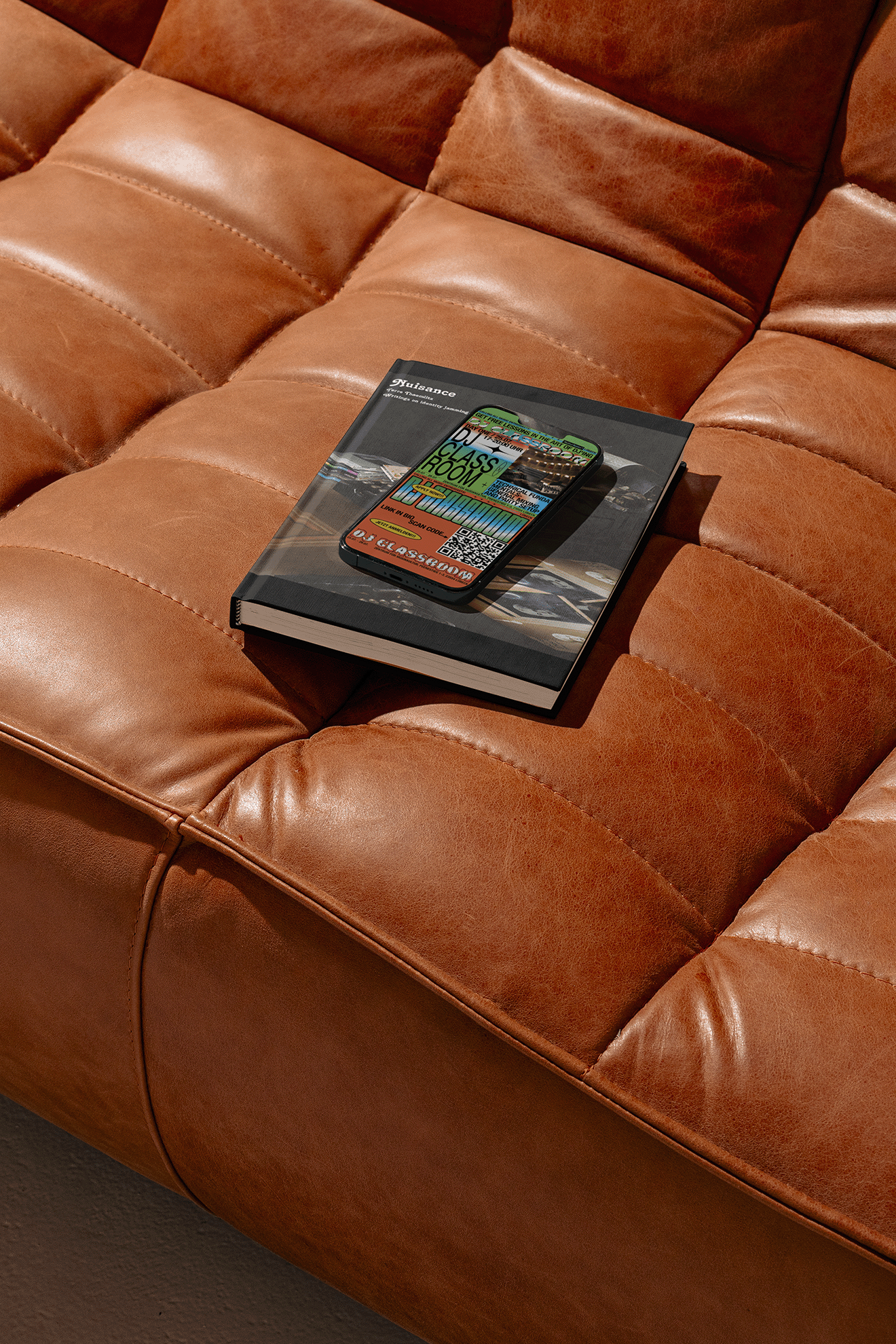 Leather sofa with a book and phone on it, the image on them