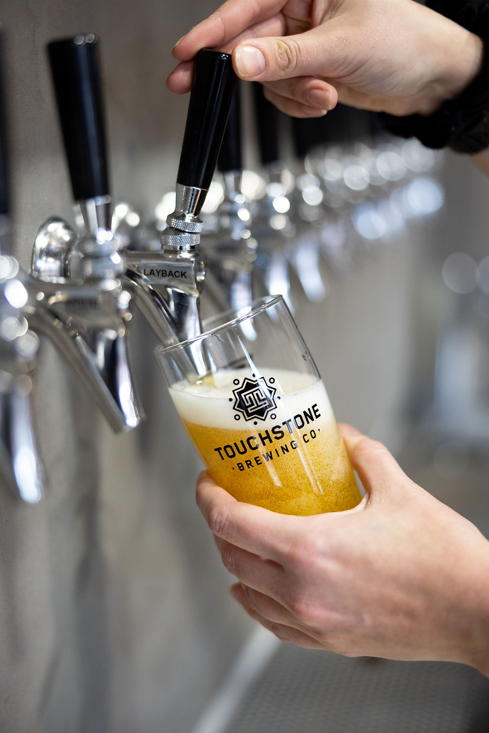 Pouring a touchstone brewing co beer from a tap
