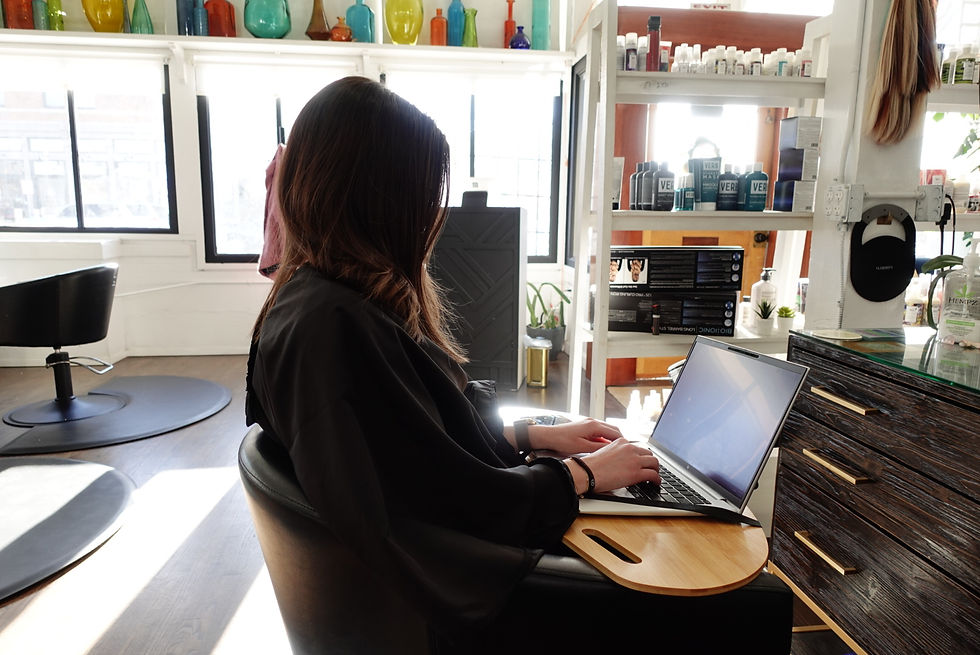 Client at the salon working on a lap desk while hair color is processing 