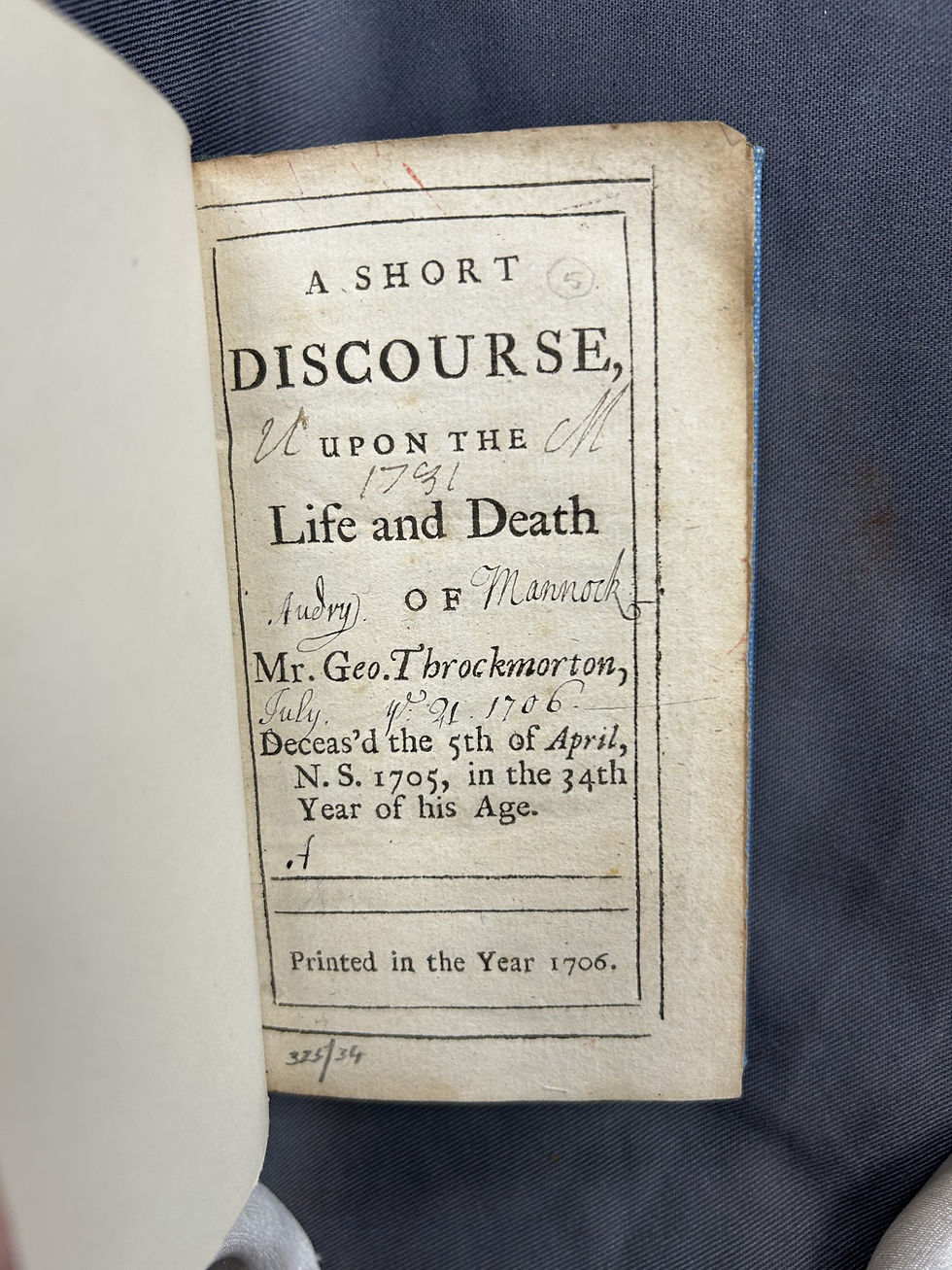 Photo of the title page of a book printed in 1706. It has 2 inscriptions, 'Audry Mannock, July ye 21 1706' and 'U M 1731'