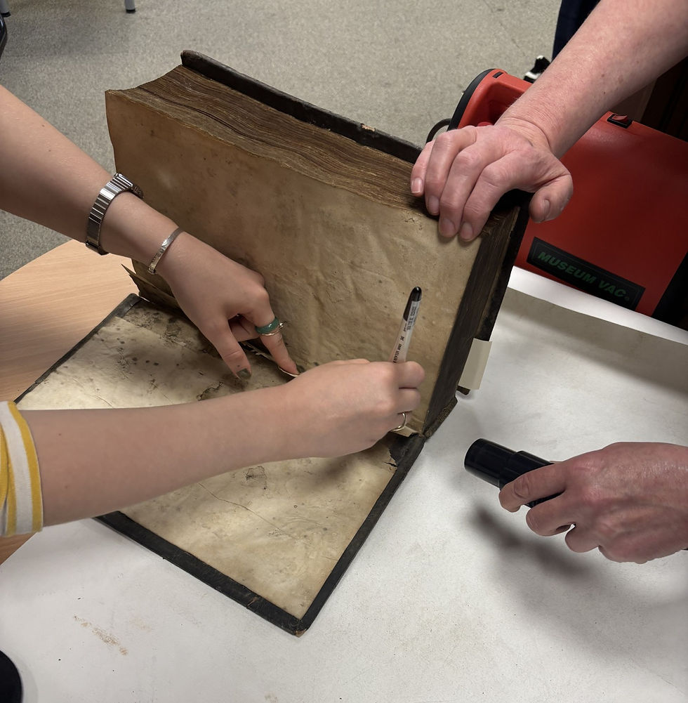 Brushing dry mould off a book into a museum vacuum cleaner