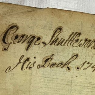 Photo of the upper part of a flyleaf with an inscription and date in black ink.