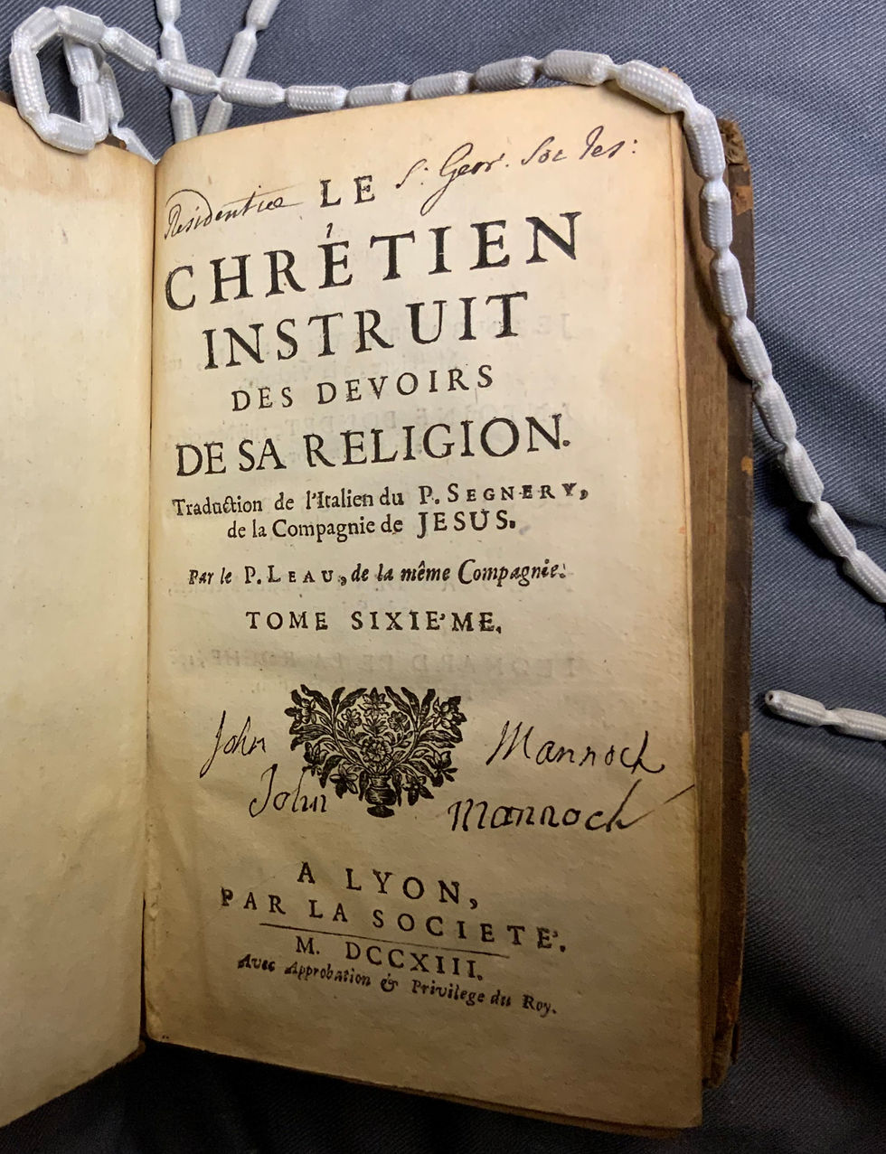 Photo of the title page of 'Le Chretien Instruit'. John Mannock has been written twice on either side of the printers device. At the top is an inscription which reads ' Residentiae S. Geor. Soc Jes:'
