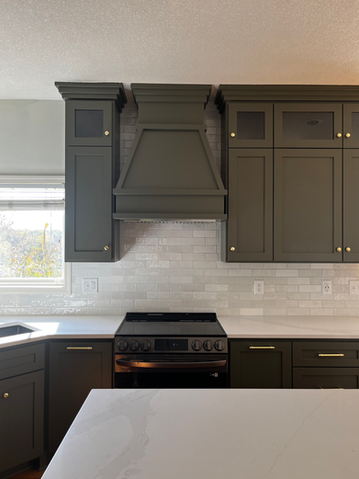 Cooking range with a sleek hood and subway style backsplash, serving as a focal point in the kitchen.