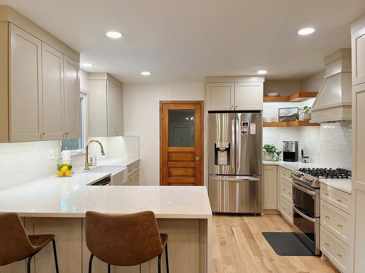 “Contemporary kitchen remodel showcasing earthy color palette, quartz surfaces, and modern hardware in a Kansas home.