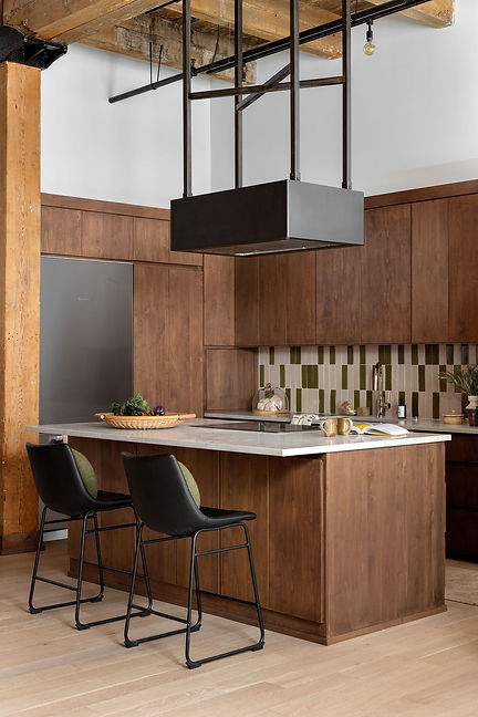 Custom walnut kitchen remodel with marble countertops, modern range hood, and green and white tile backsplash in a Kansas City home