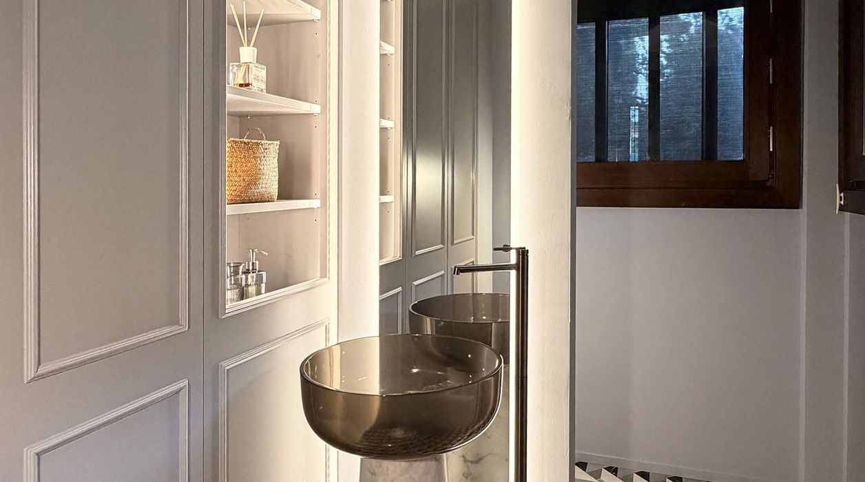 Lavabo marrone e bianco con specchio e pavimento decorativo in bagno.