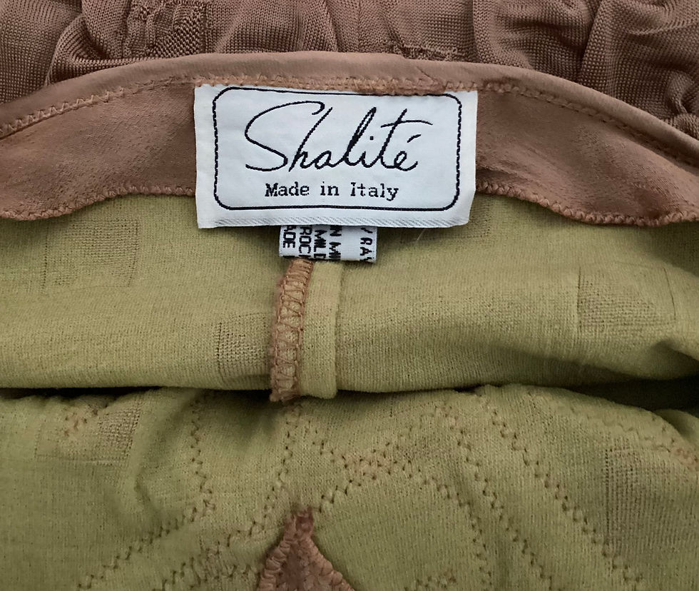 Thumbnail: Close-up of Shalité label, Made in Italy, on brown and green fabric.