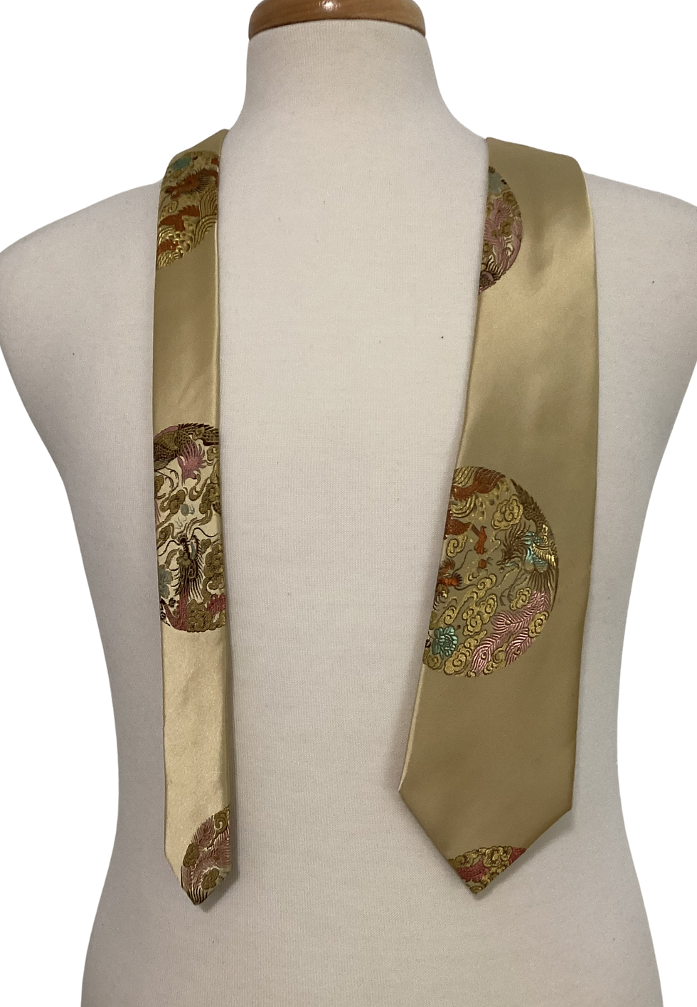 Gold tie with brown circles, displayed on a mannequin, front view