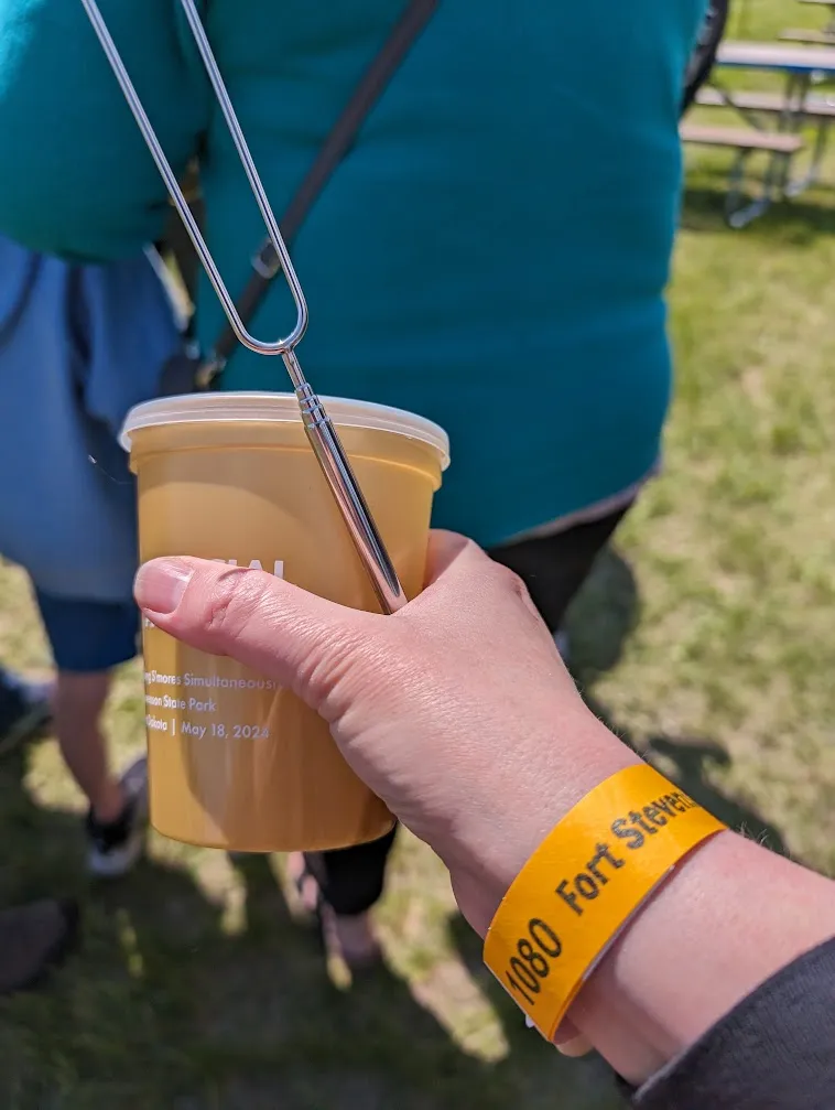 hand holding roasting stick and cup