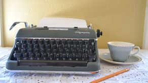 typewriter next to tea cup