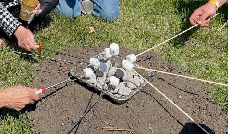 people roasting marshmallows over coals