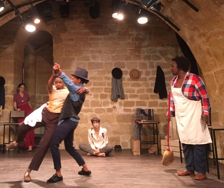 Two actors dancing while others look on