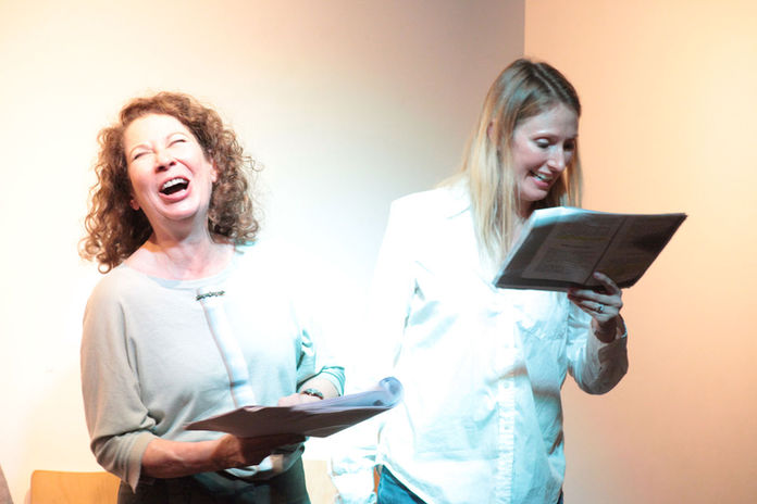 2 actresses laughing with script