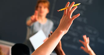 A hand up in a classroom