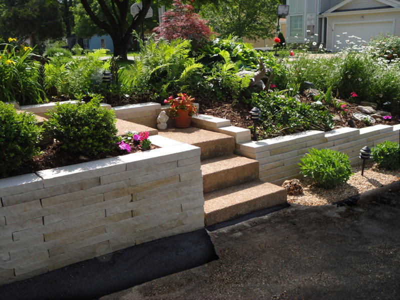 A St.Louis residence with fresh landscaping, including new plants and a natural stone retaining wall.