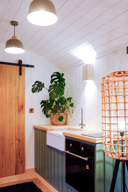 Shepherd hut kitchen with handmade fluted belfast sink, and sliding oak door that leads into shower room.