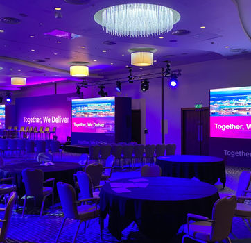 Angled view of awards stage with LED screens, central scenic backdrop and event lighting for Heathrow 2023