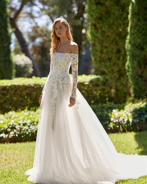 Demet Adriana Alier - Schulterfreies A-Linien-Brautkleid aus fließendem Soft-Tüll und Blumen-Spitze mit einer halb-transparenten Korsage, mit langen Ärmeln, einer Knopfleiste und mit Schleppe. Das perfekte Brautkleid für eine romantische Hochzeit. Ideal für eine kirchliche Trauung oder für eine freie Trauung geeignet. 