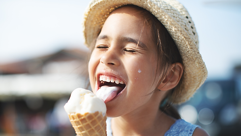 background image of a little girl eating ice cream from Vero Beach ice cream shop with a big smile