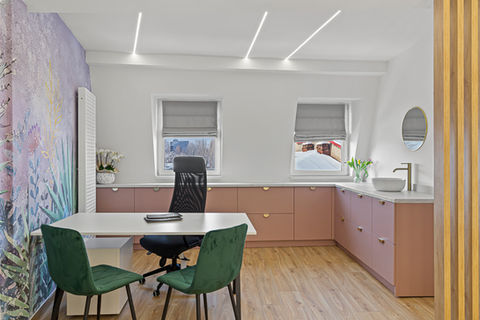 Vedere completă a unui cabinet medical modern, cu mobilier roz pudrat, scaune verzi, perete decorativ floral și iluminat liniar – proiect The City Clinic 01, București.