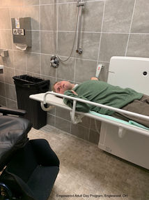 Man demonstrating universal changing table pressalit 1000 at Empowered adult say services Dayton Ohio