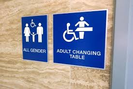 Restroom signs that say "All gender" and "adult changing table". 